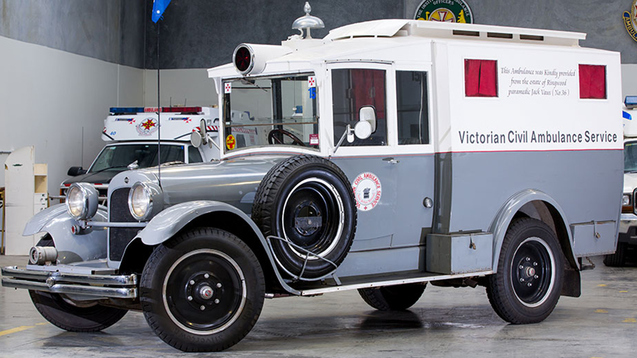 A vintage ambulance parked inside a garage, showcasing its classic design and historical significance.