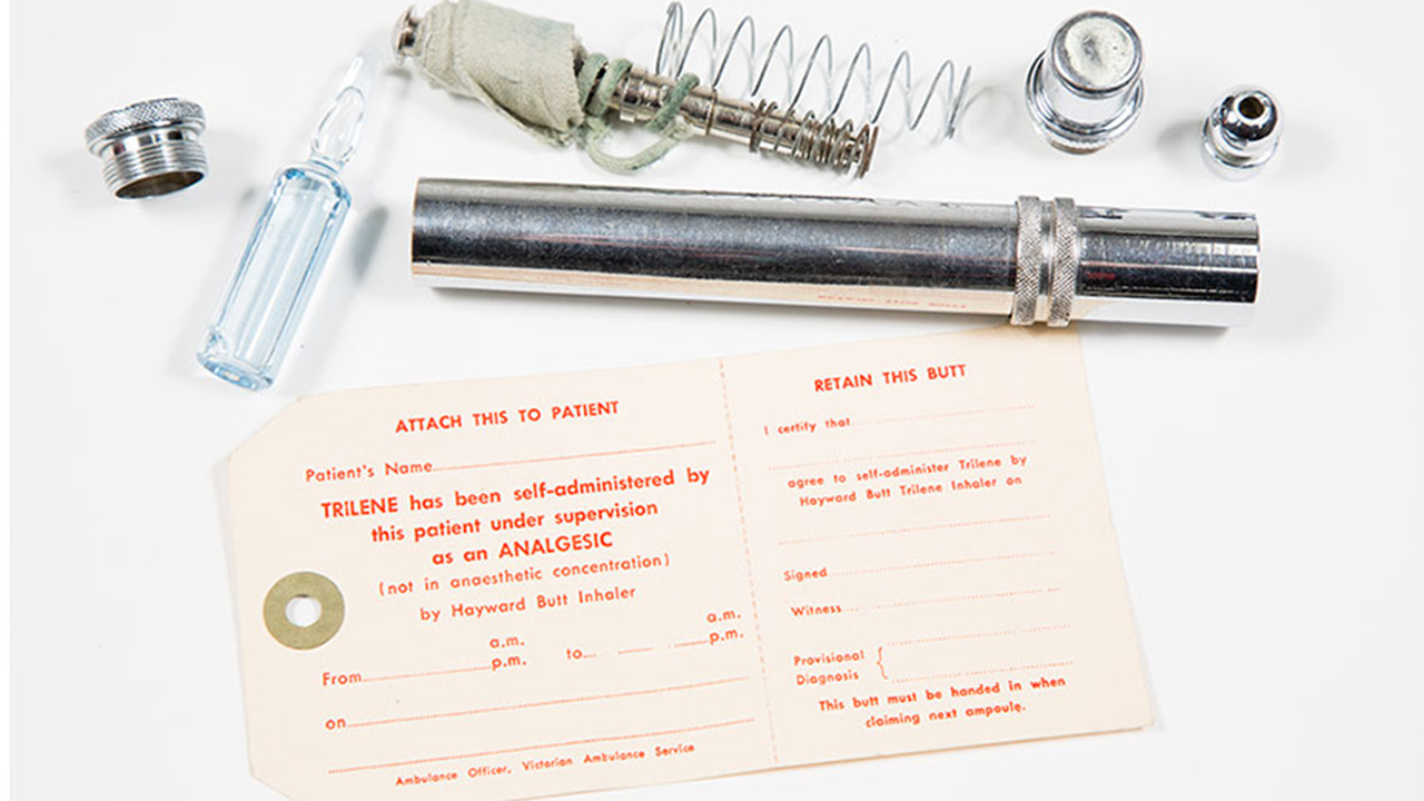A metal tube accompanied by a piece of paper and a bottle.