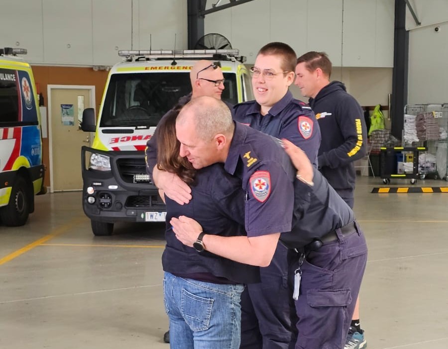 A paramedic hugs a woman.