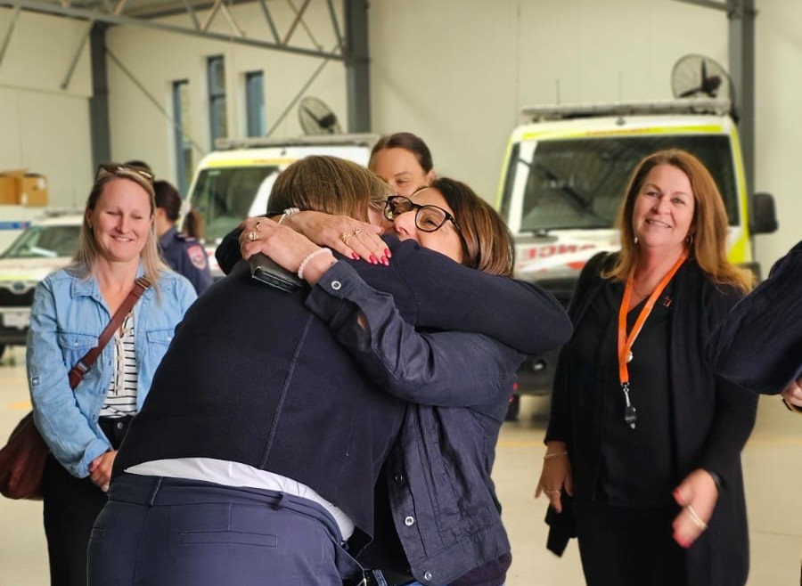 Two women hug.
