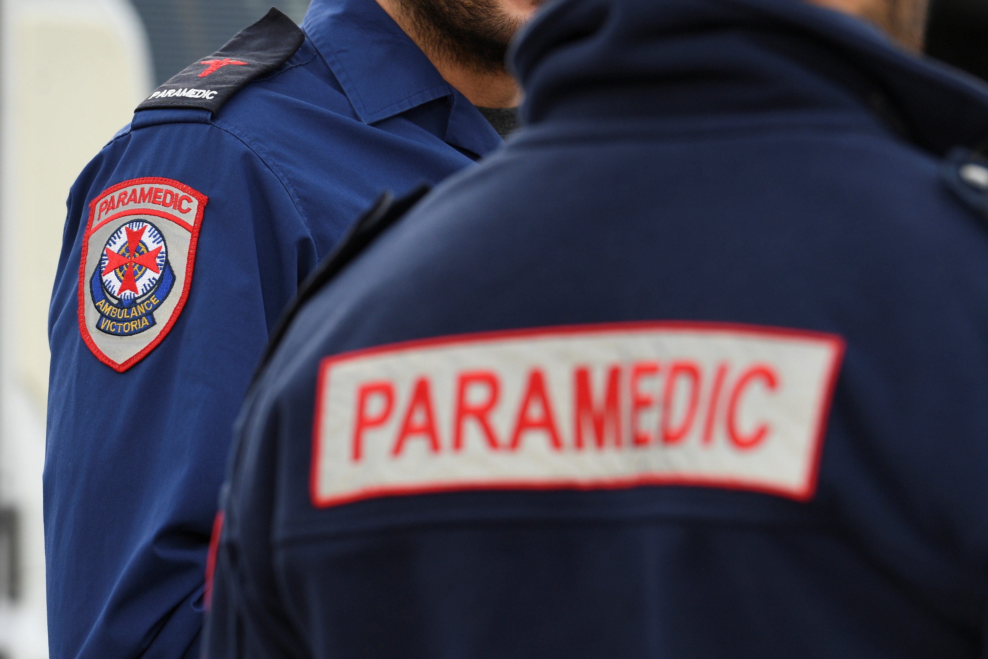 A photo showing the Ambulance Victoria emblem on a paramedic's uniform and 'PARAMEDIC' written on the back of a uniform.