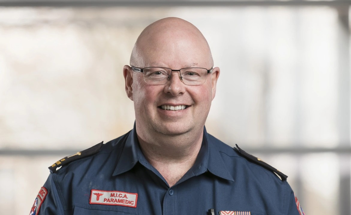 A man in MICA paramedic uniform stands for a posed photo